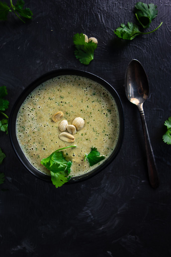 bowl of sauce garnished with peanut and herbs