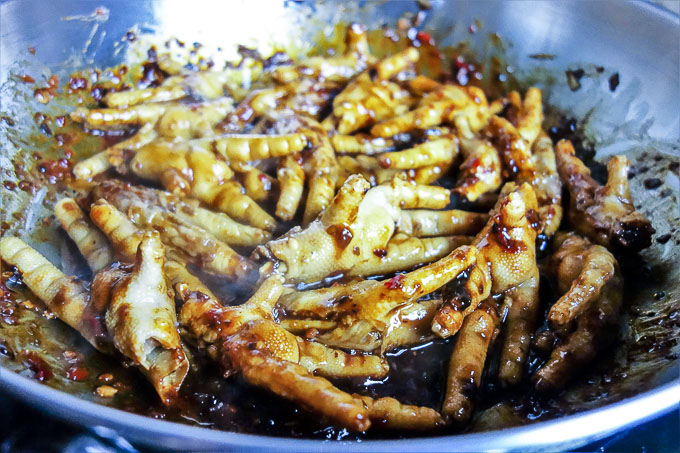 braised chicken feet in a skillet being cooked
