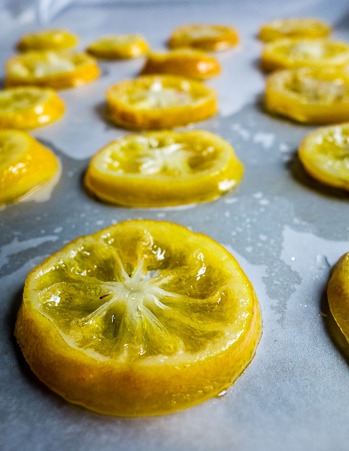 freshly candied lemon slices drying on baking sheet
