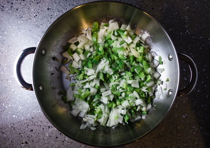 green peppers and onions in a saute pan