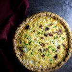 quiche in a pie crust on a dark background