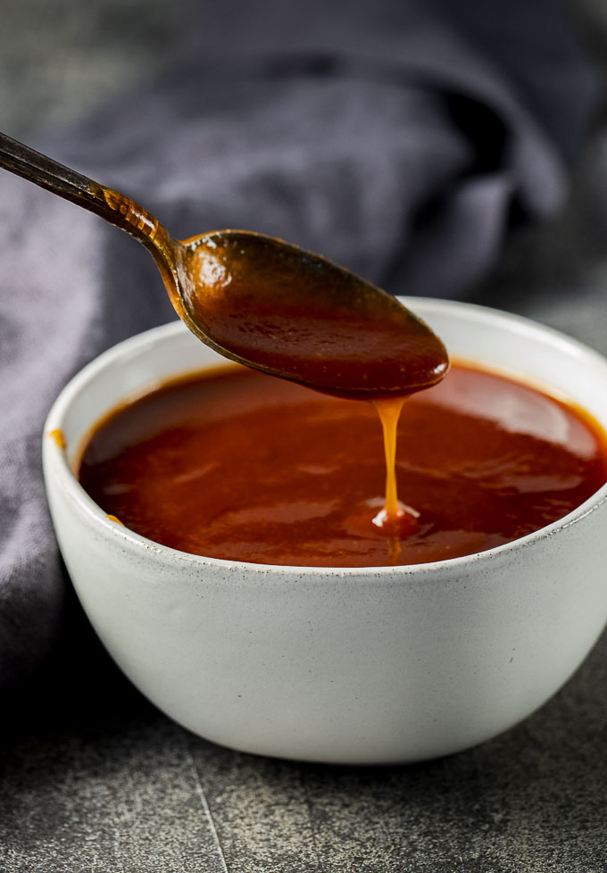 barbecue sauce being drizzled with a spoon