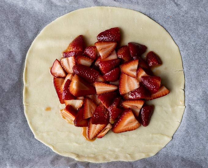 sliced strawberries on a rolled out pie crust