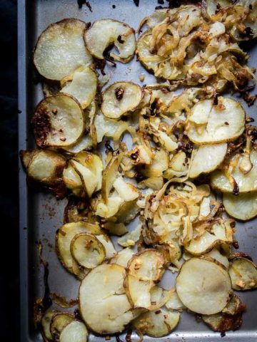 cirspy potatoes and onions on baking sheet