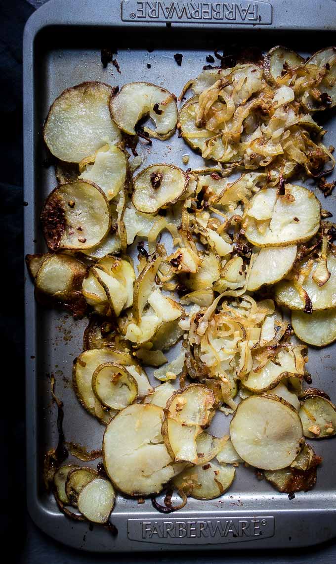 cirspy potatoes and onions on baking sheet