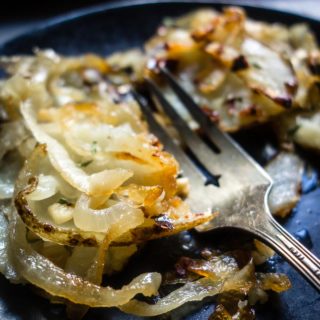 crispy potatoes and onions on plate with fork