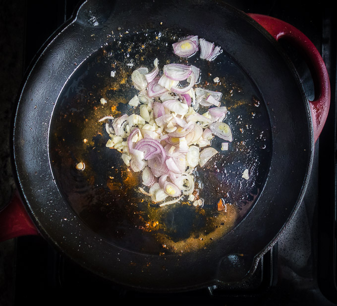 garlic, onions and thyme browning in cast iron skillet