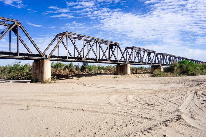 a railroad bridge over sandy river bed, roadtrip from san diego to tucson