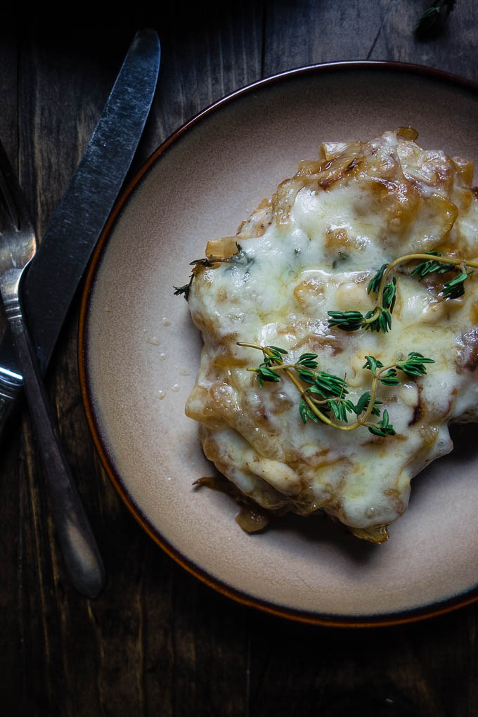 close up of pork chops smothered in cheese, french onion smothered pork chops