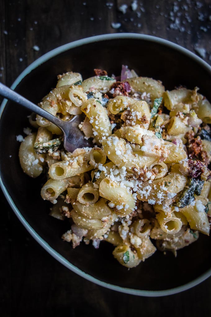 bowl of macaroni with a creamy sauce, peppers, chorizo and sprinkled with crumbly cheese