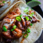 pork on a flour tortilla with green onions and kimchi
