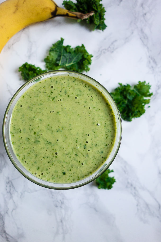 green smoothie with kale in background