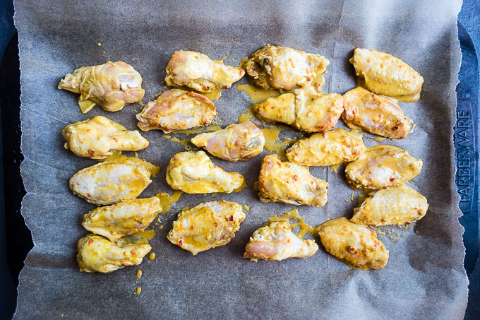 chicken wings on a baking sheet lined with parchment paper