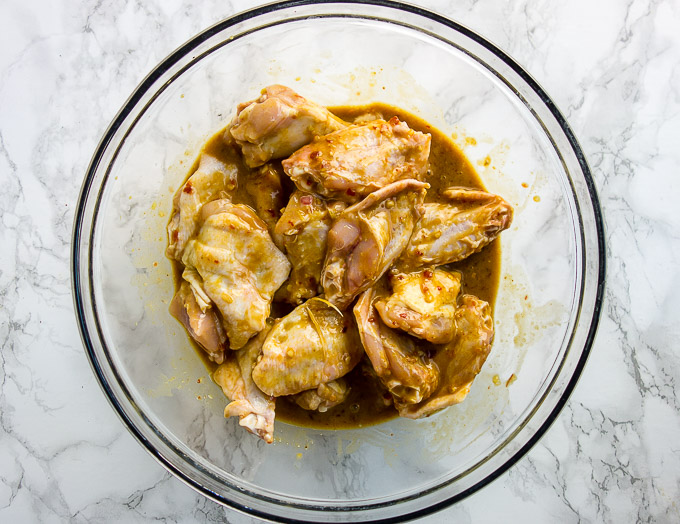chicken in marinade in a glass bowl
