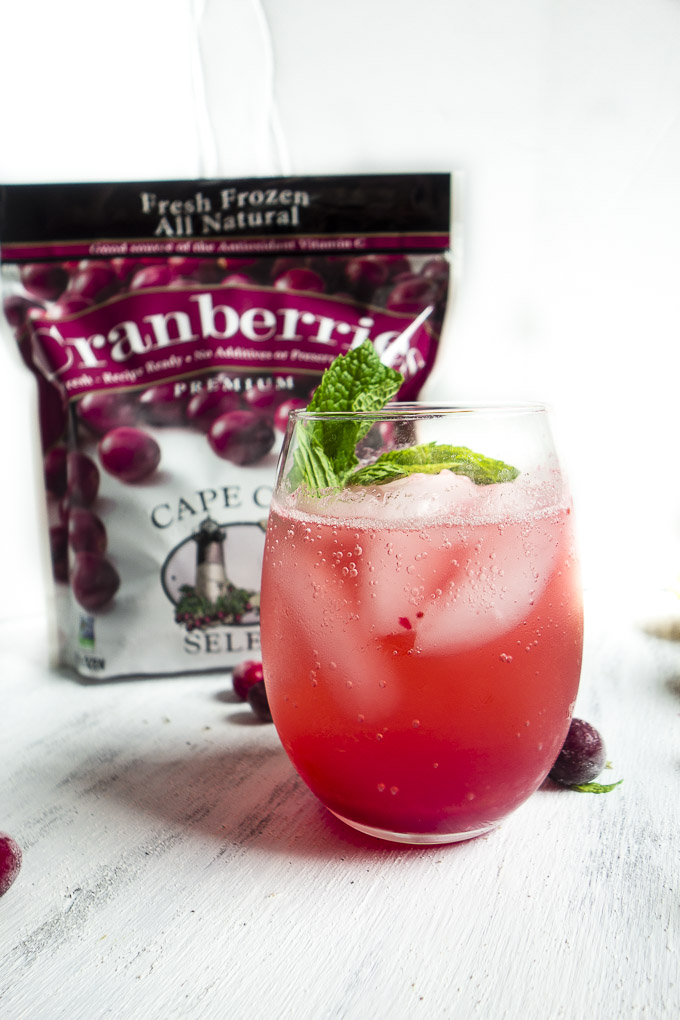 aprkling cranberry lemonade with bag of cranberries and fresh mint