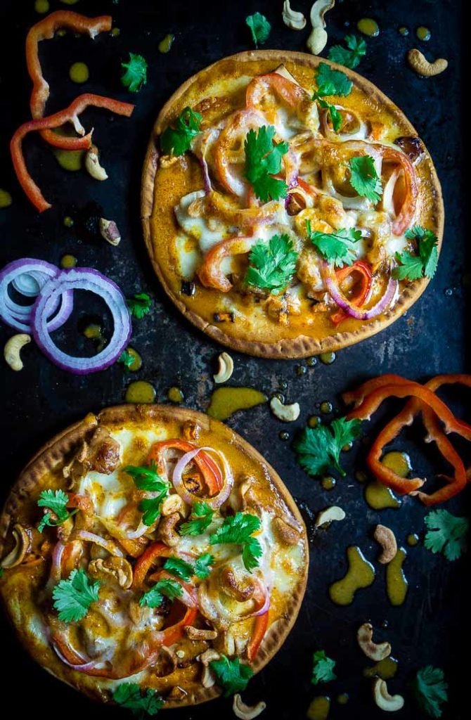 2 thai chicken flatbread pizzas garnished with vegetables and curry sauce