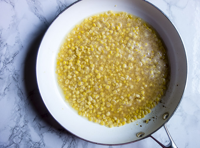 corn and broth in a skillet
