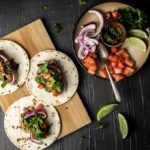 tacos on a platter with garnishes
