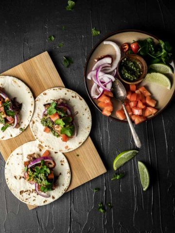 tacos on a platter with garnishes