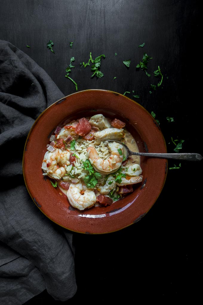 brazilian fish stew in a bowl with fresh shrimp, rice and tomatoes, garnished with cilantro