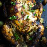 whole indian spiced roasted chicken garnished with parsley and potatoes