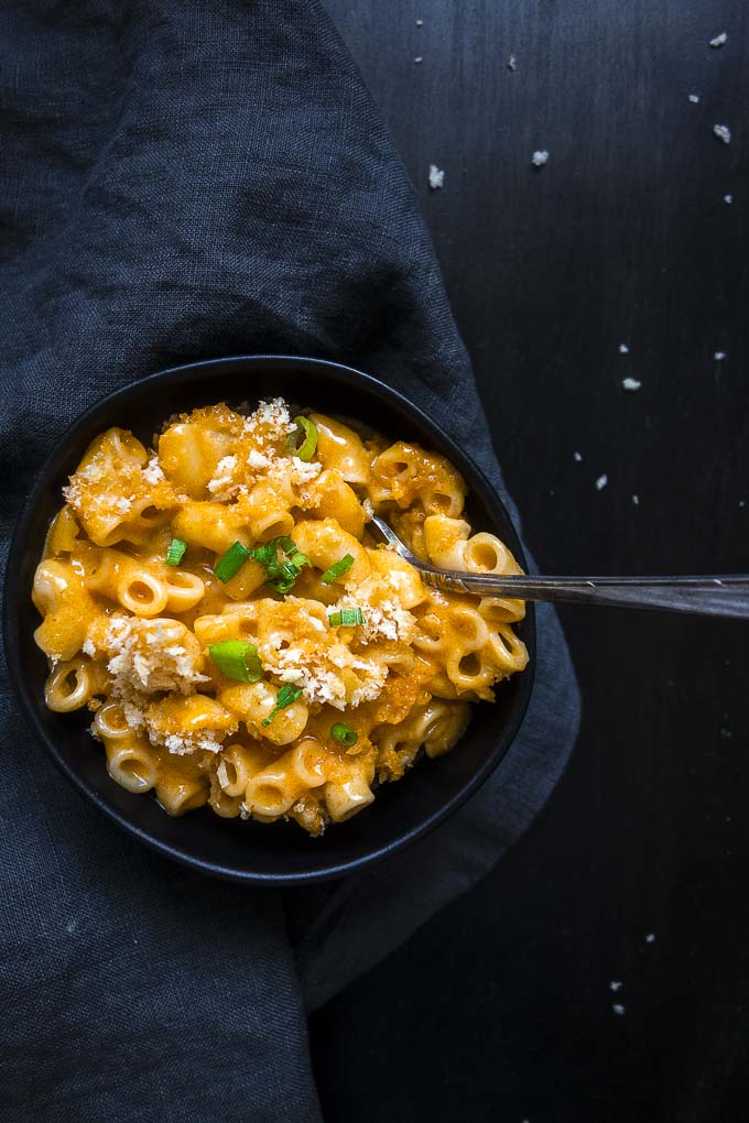 thia red curry mac and cheese in a bowl with green onions