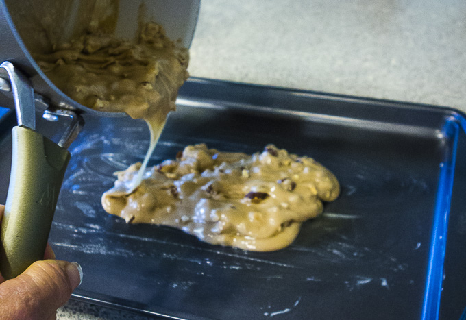 pouring buttercrunch on a greased baking sheet