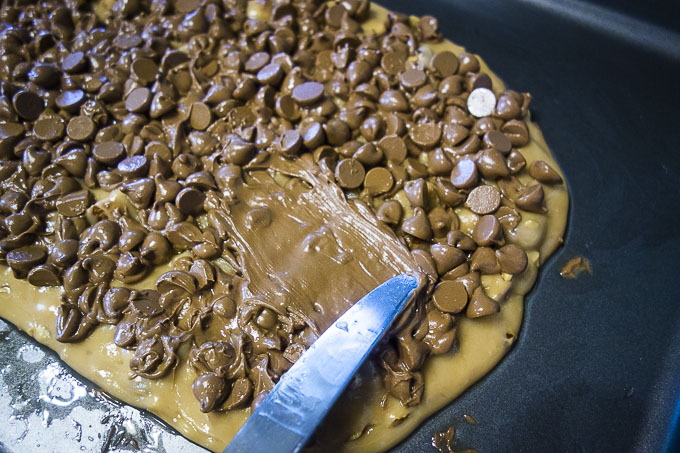 spreading chocolate on buttercrunch with a knife