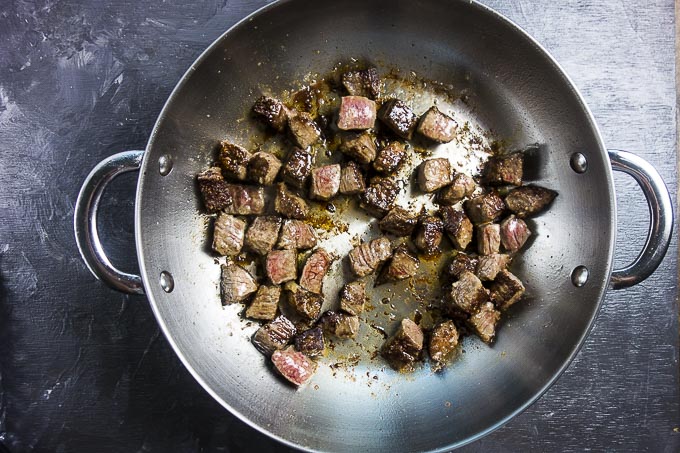 seared beef pieces in a skillet