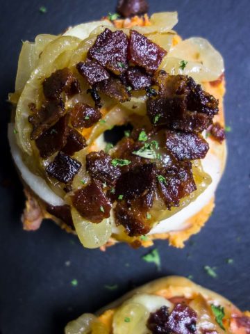 close up of mini bagel bites topped with bacon and apple