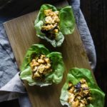 ground chicken in cups of lettuce on a wood board