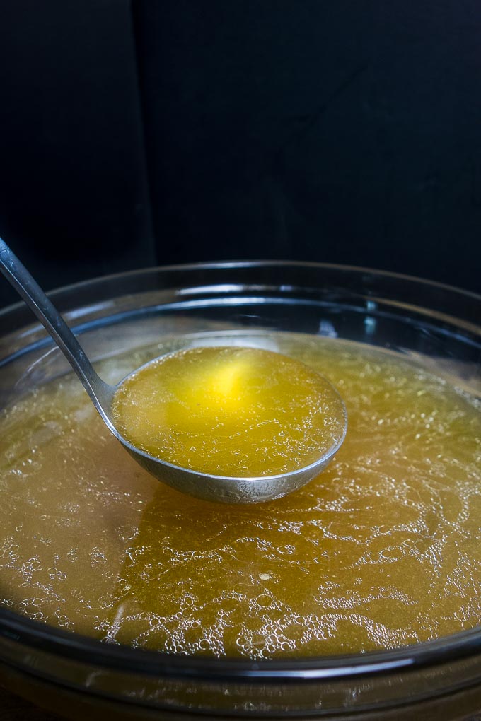 ladle full of instant pot chicken bone broth - side view