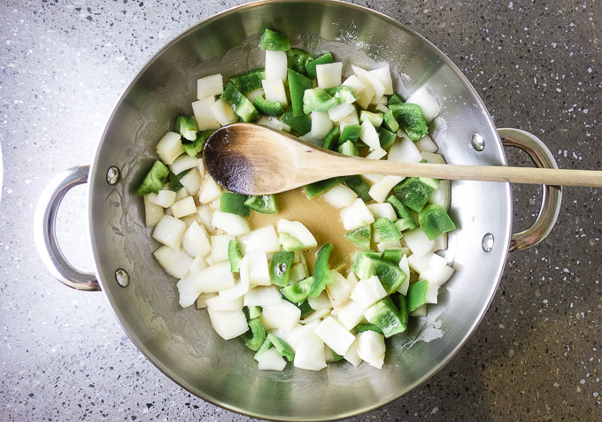 onions and green peppers in a skillet with blond roux
