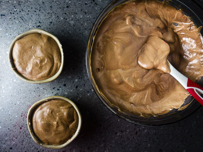 chocolate souffle batter in a bowl and in 2 ramekins