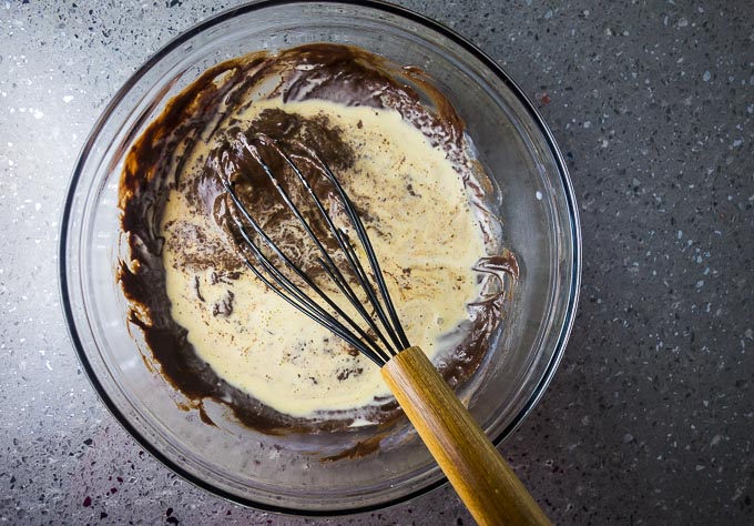 egg yolks being mixed into chocolate batter
