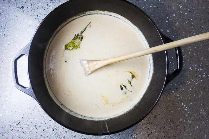 coconut milk broth with lime leaves in a dutch oven