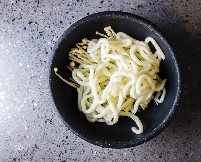 noodles and enoki mushrooms in a bowl