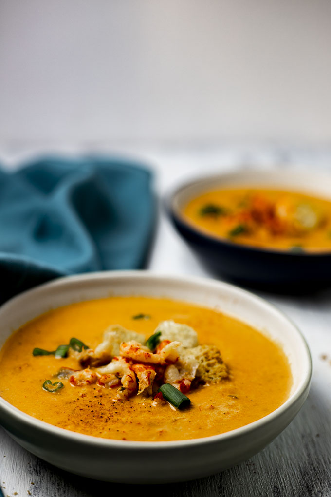 side view of a bowl of bisque with crawfish