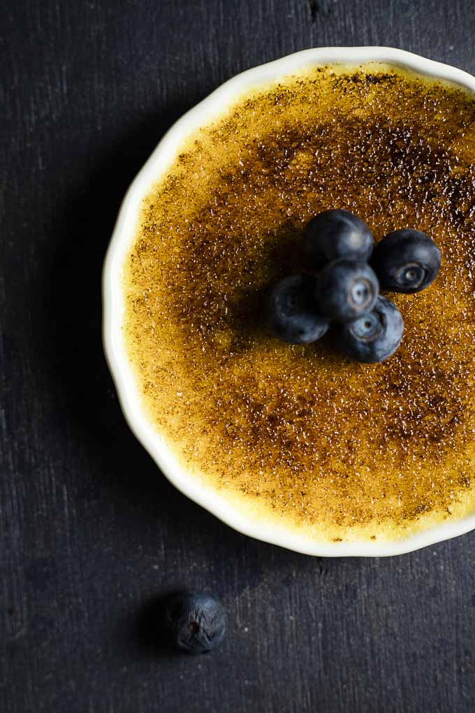 close up up creme brulee topped with fresh blueberries