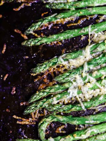 close up of asparagus with crispy browned cheese on top