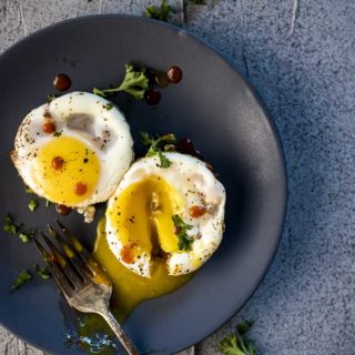 egg cups on a plate with runny egg yolk top down view