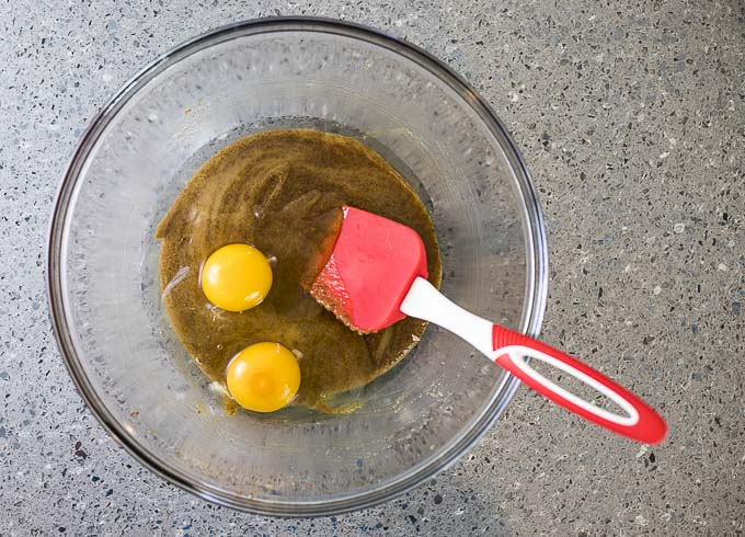 2 eggs in brown sugar mixture in a bowl