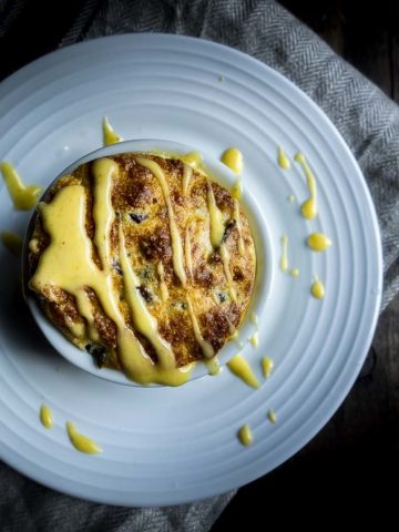 cheese souffle in a ramekin drizzled with hollandaise