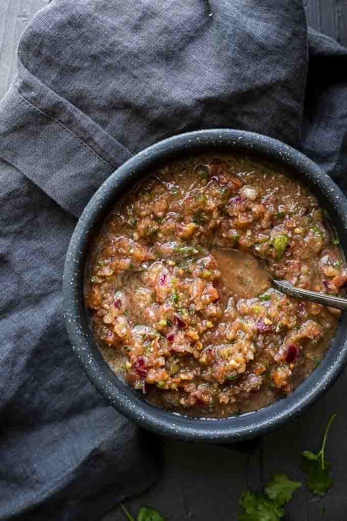 bowl of tomato salsa with a spoon in it