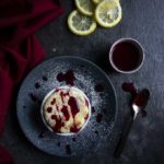 souffle drizzled with raspberry sauce on a plate with lemon slices in the background