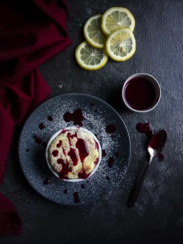souffle drizzled with raspberry sauce on a plate with lemon slices in the background