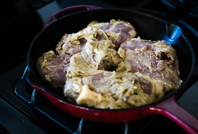 raw chicken thighs in a cast iron skillet