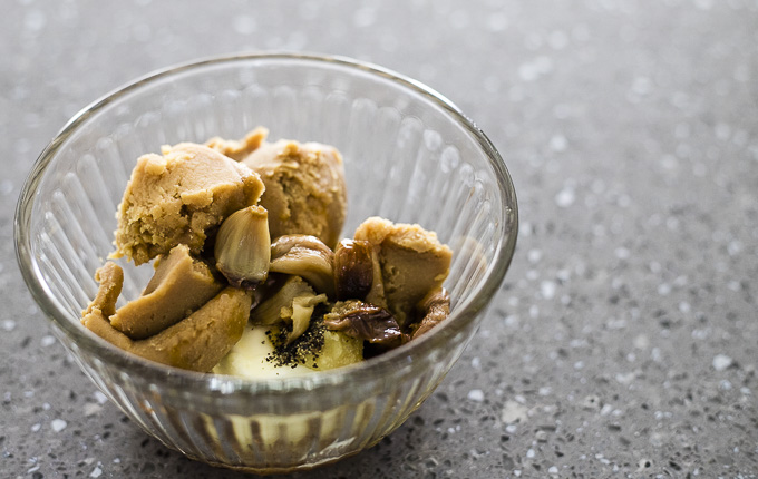 miso paste, garlic cloves and seasonings in a glass bowl