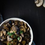 top down view of a bowl of sauteed mushrooms garnished with parsley