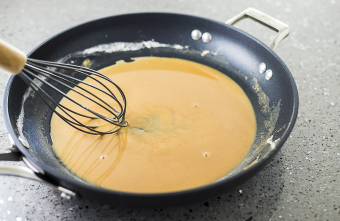 brown liquid being whisked in a skillet